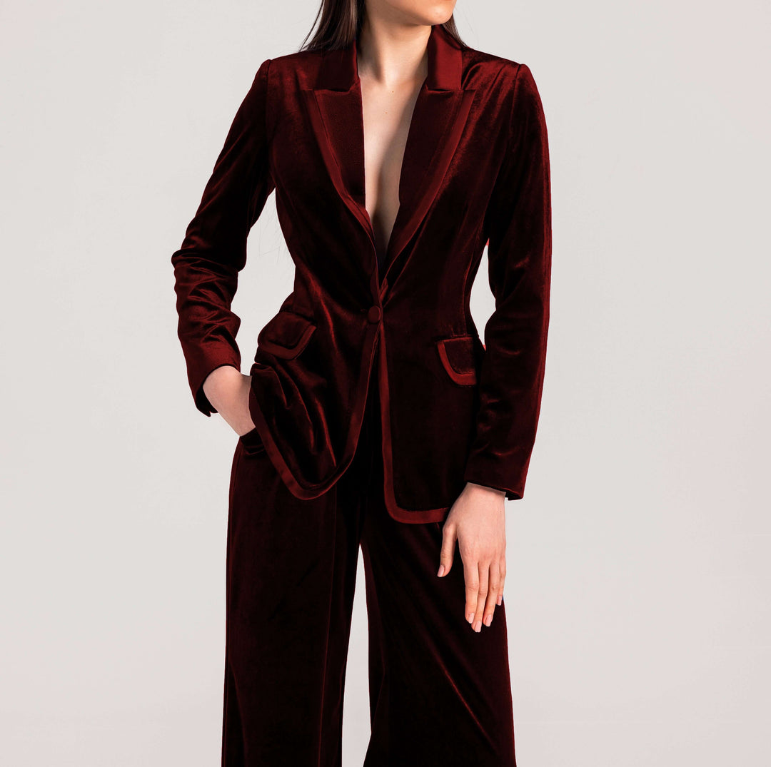 Woman wearing elegant deep burgundy velvet suit with blazer and wide-leg pants