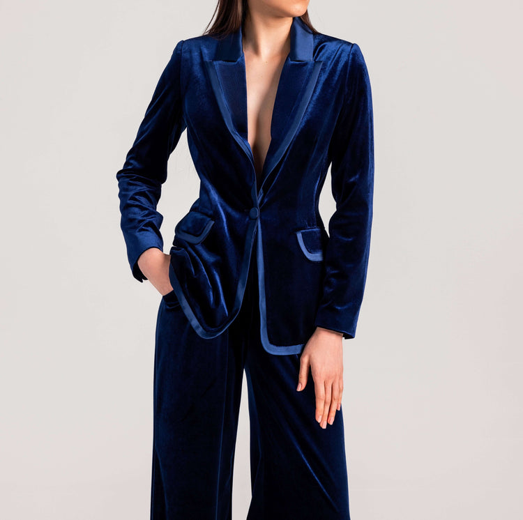 Woman in elegant deep blue velvet suit with notch lapel blazer and matching pants