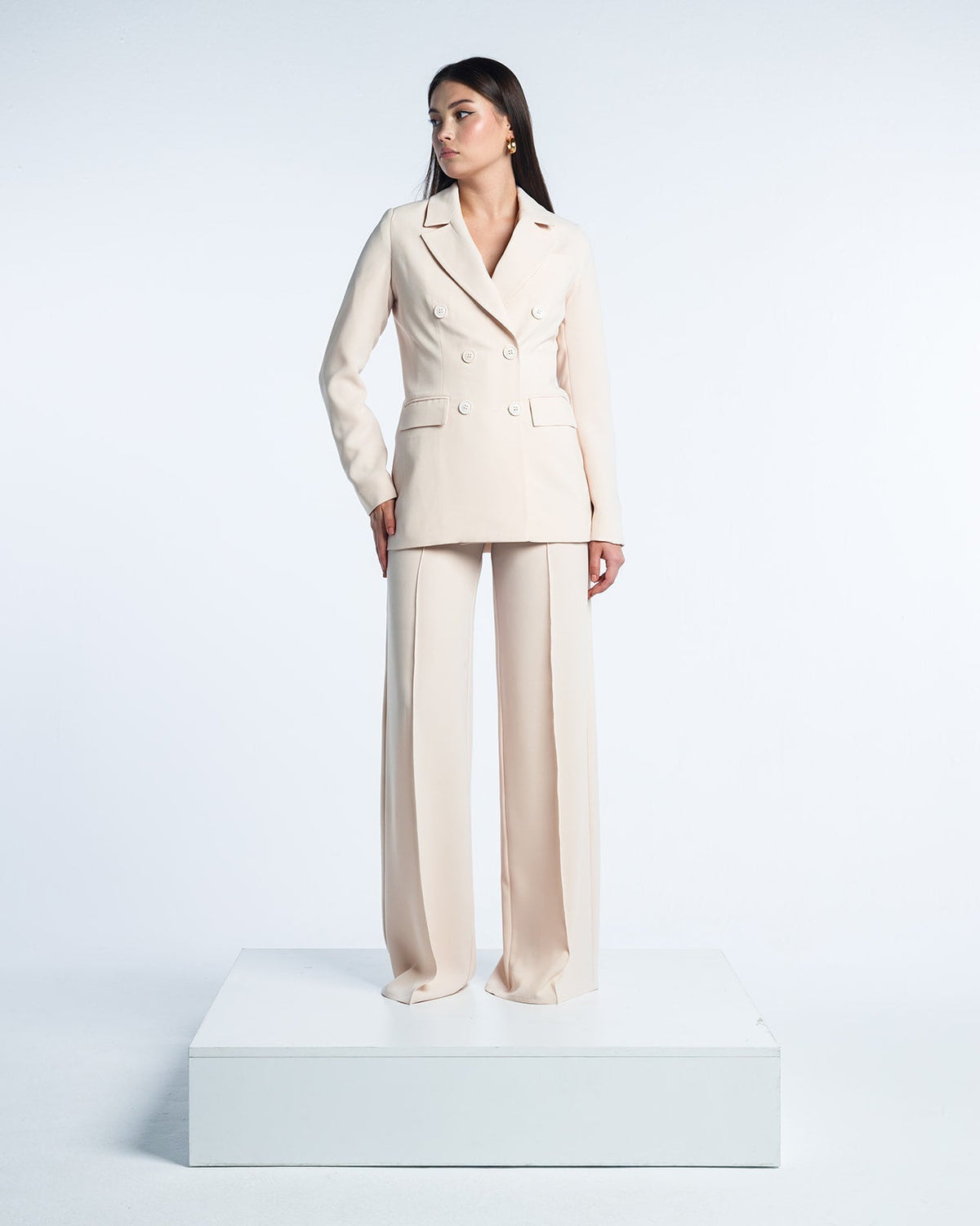 Woman modeling an elegant beige double-breasted suit with wide-leg trousers