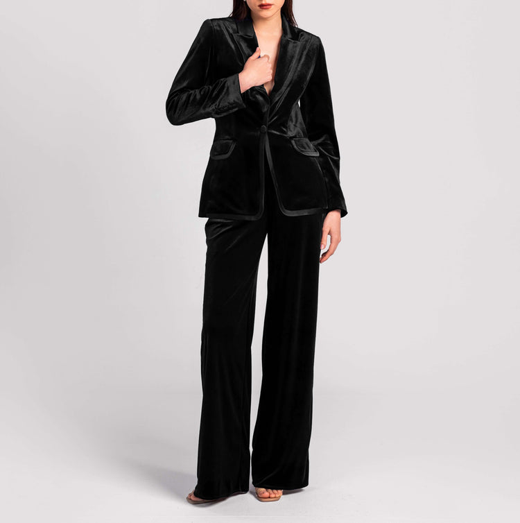 Woman wearing elegant black velvet suit with tailored blazer and wide-leg pants