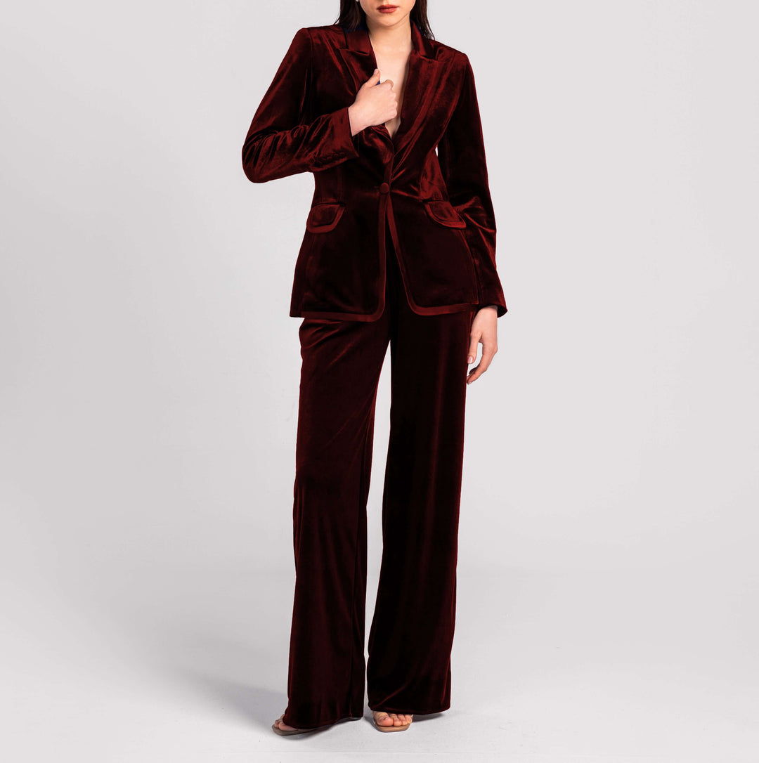 Woman wearing elegant burgundy velvet suit with blazer and wide-leg pants, fashion style