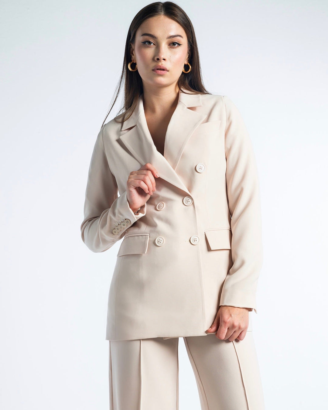 Woman modeling a beige double-breasted blazer and wide-leg suit pants set