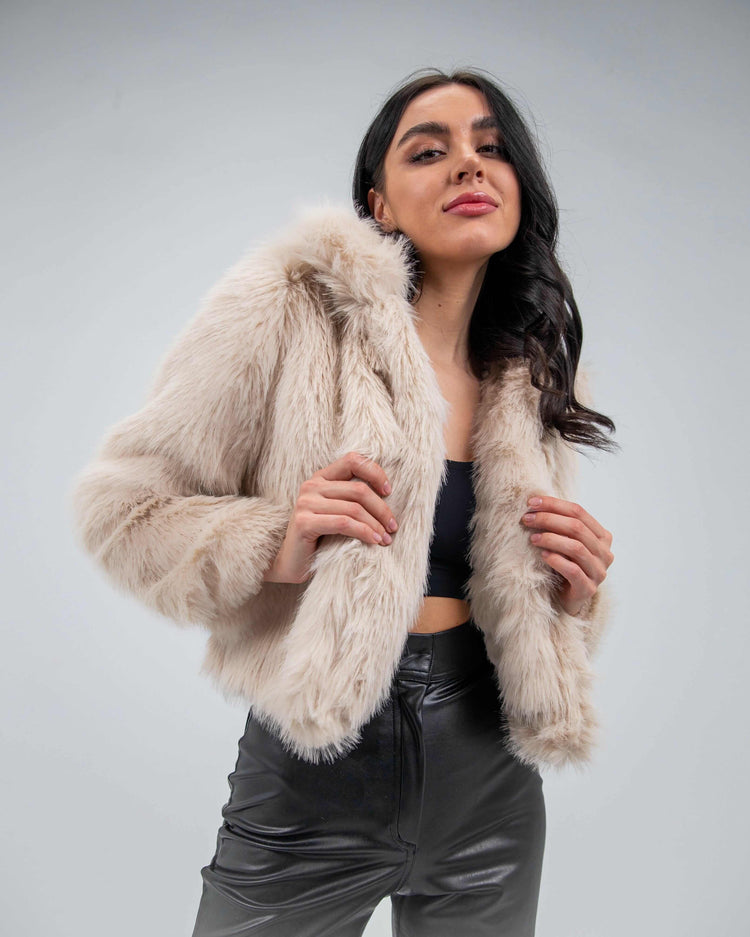 Woman wearing beige faux fur jacket and black leather pants, stylish winter outfit