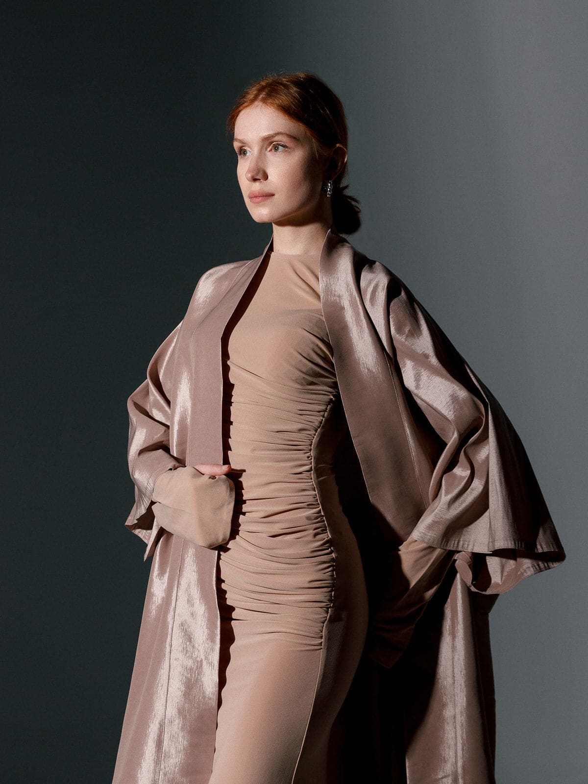 Woman wearing a beige oversized organza kimono over a fitted ruched dress in studio lighting