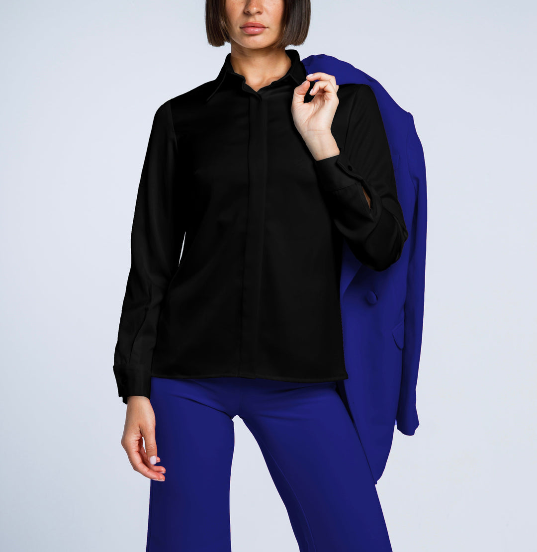 Woman wearing a black long-sleeve shirt, royal blue pants, holding a matching blue blazer