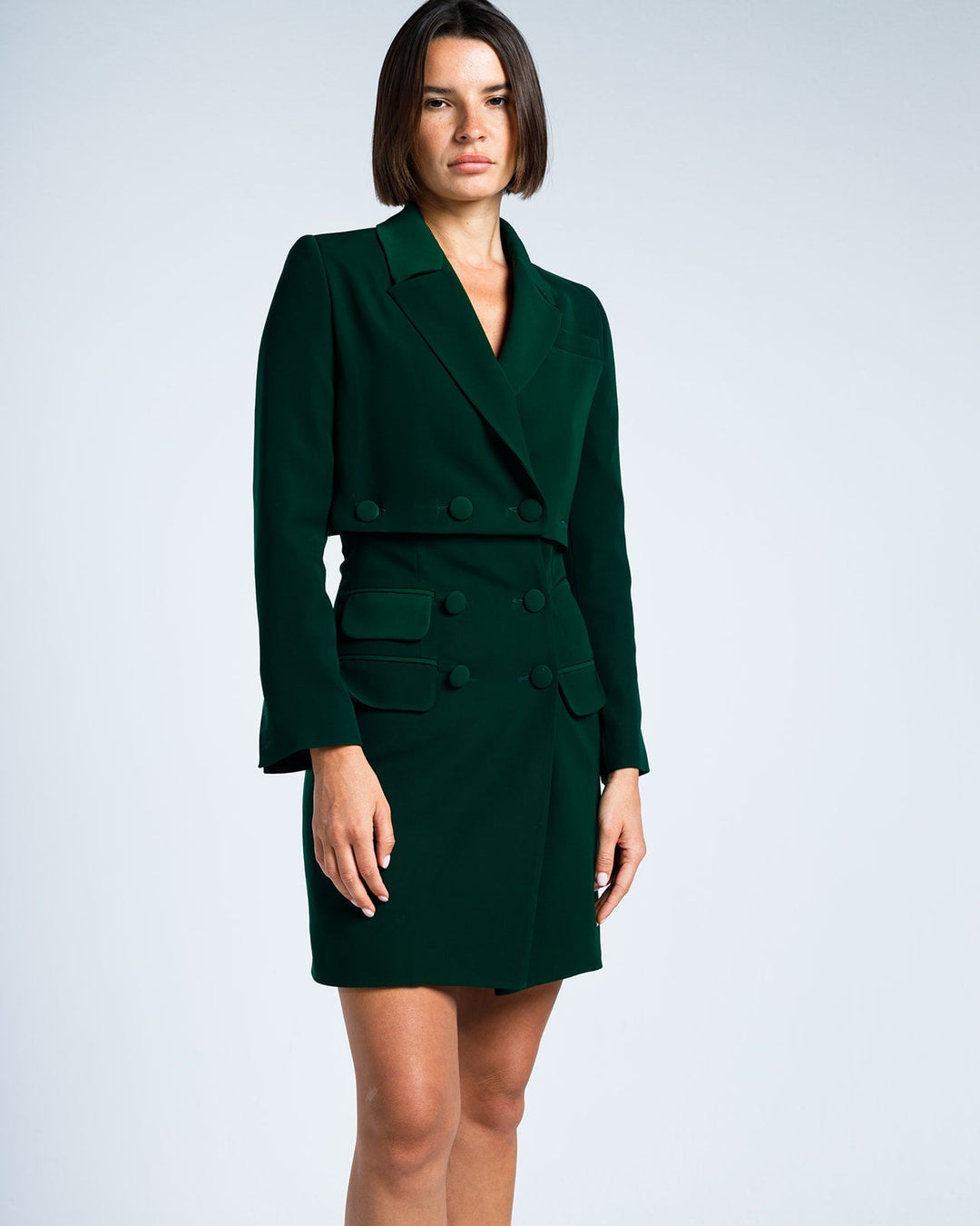 Woman wearing dark green double-breasted blazer dress with long sleeves and notched lapels