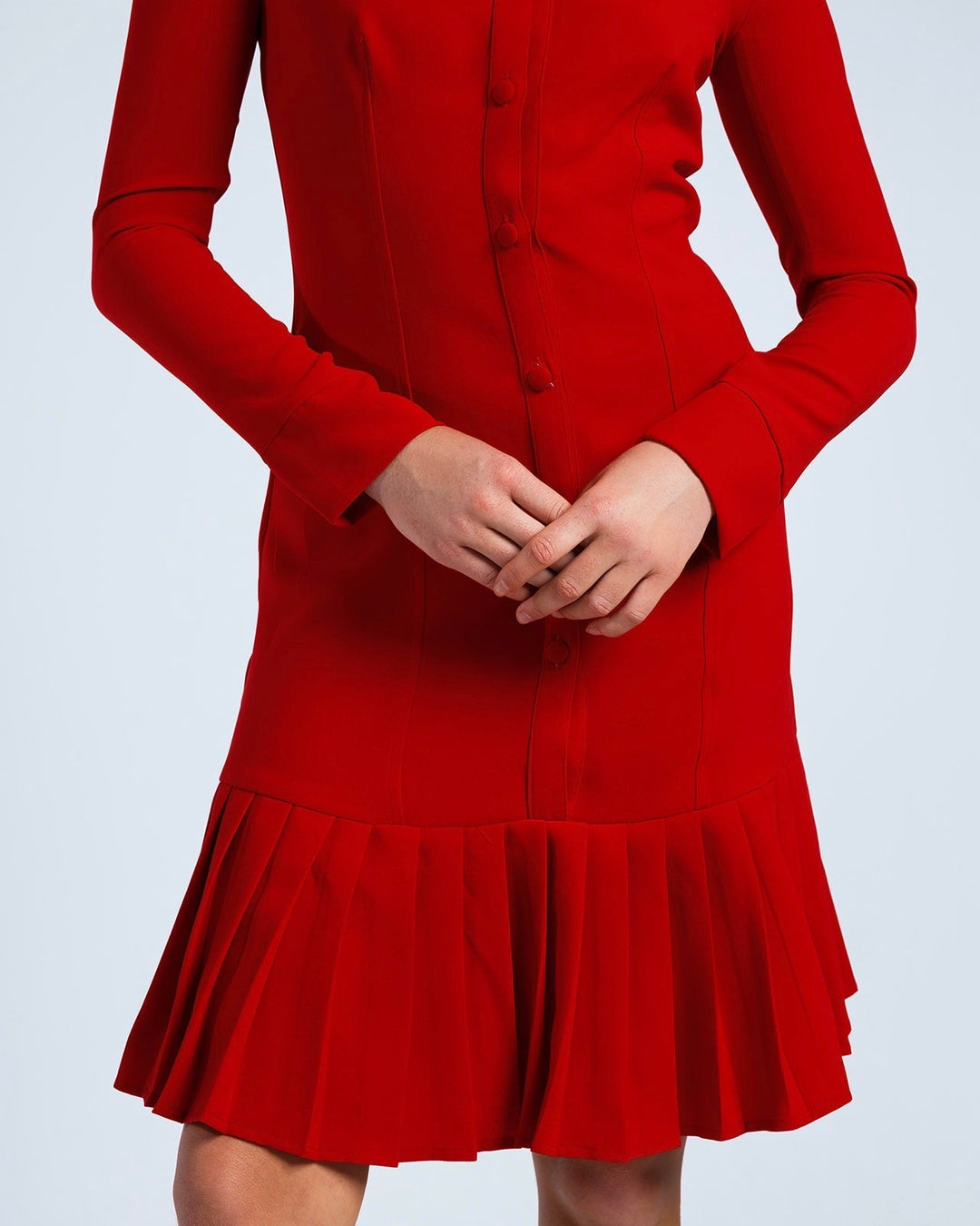 Elegant long sleeve red dress with button front and pleated skirt, modeled against white background