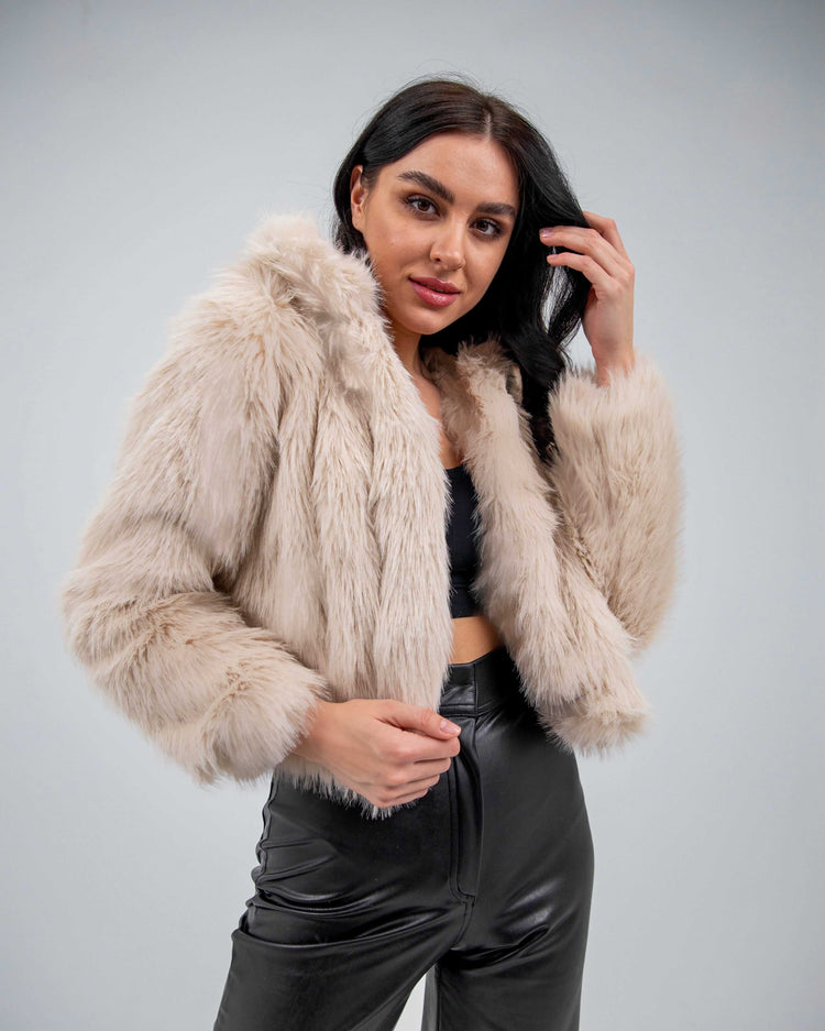 Woman in beige faux fur jacket and black faux leather pants, stylish winter fashion
