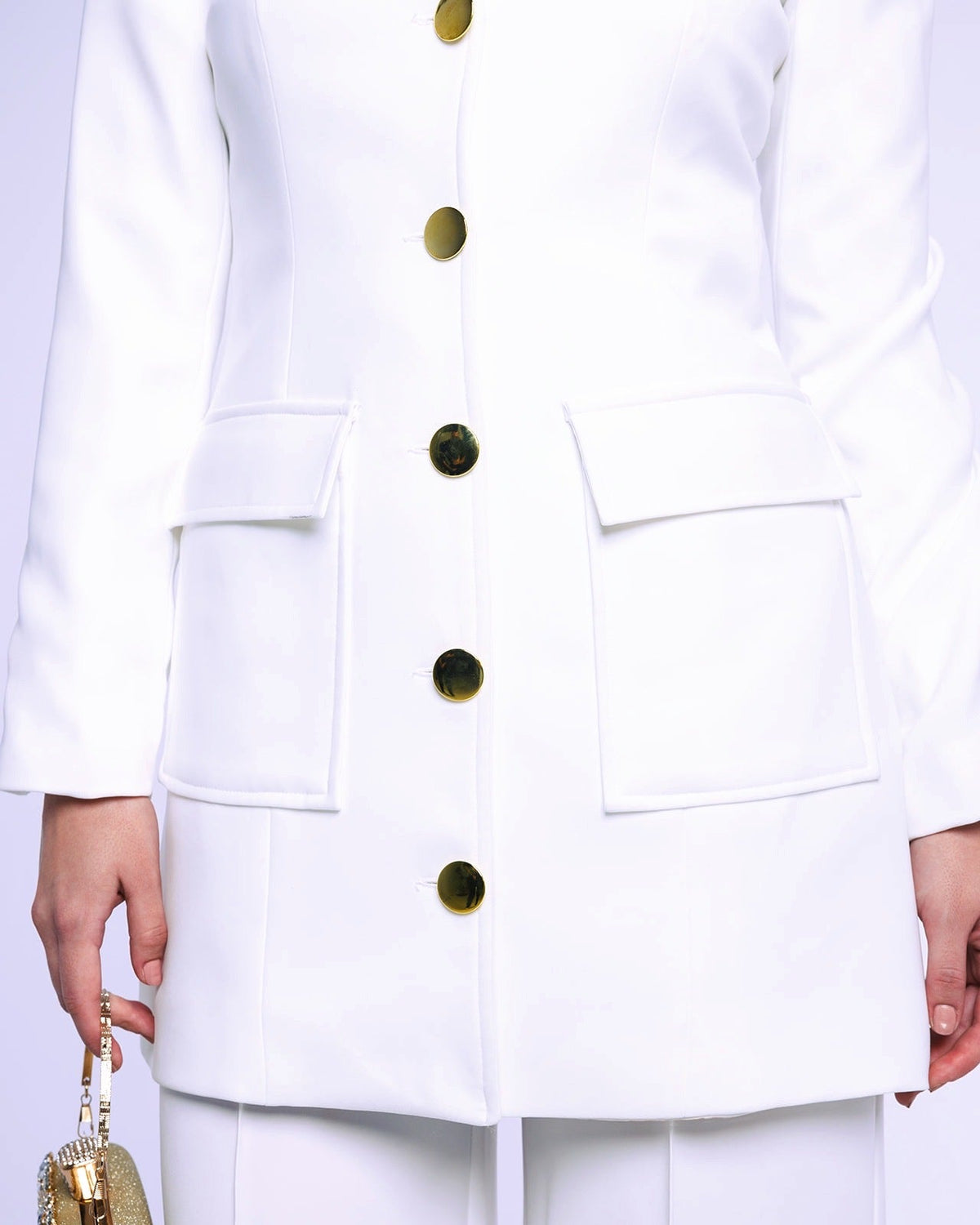 White tailored blazer with gold buttons and flap pockets, paired with white pants