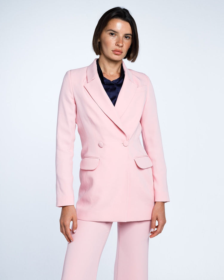 Woman wearing elegant light pink tailored suit with double-breasted blazer and matching pants