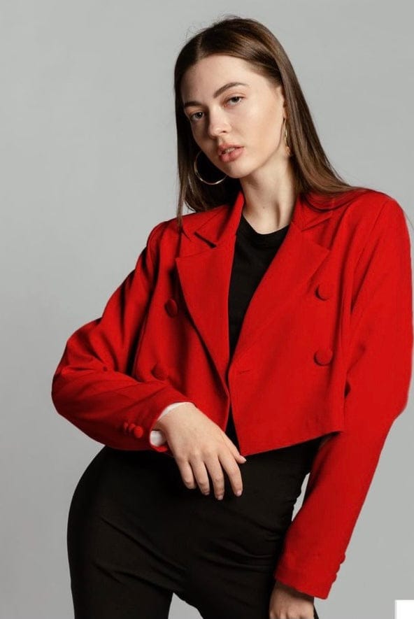 Woman wearing a stylish cropped red blazer with black pants and hoop earrings