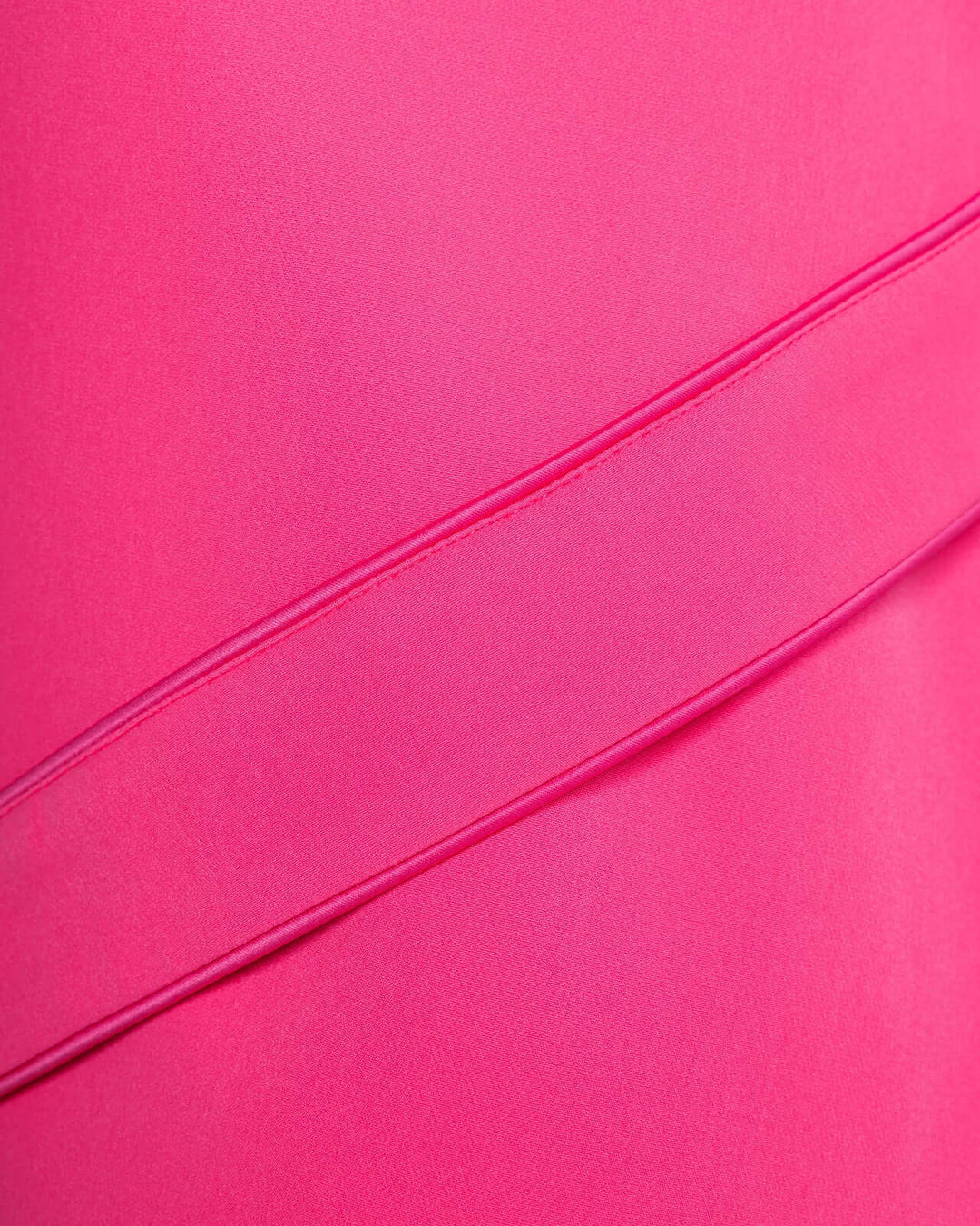 Close-up of vibrant pink dress fabric with diagonal seam detail