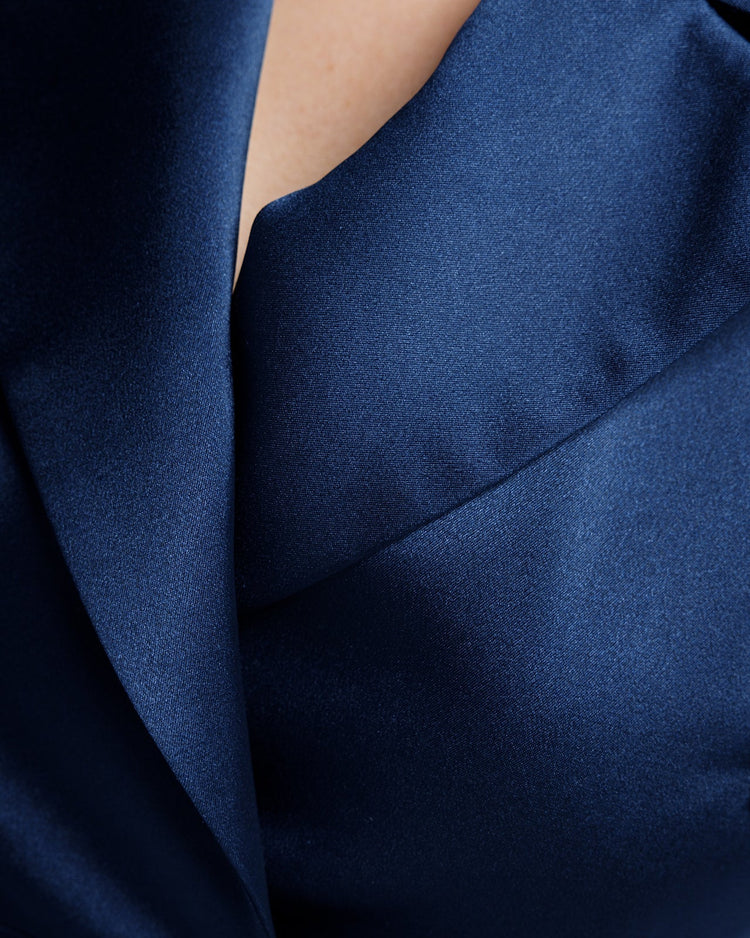 Close-up of elegant deep blue satin suit lapel and collar with smooth fabric texture