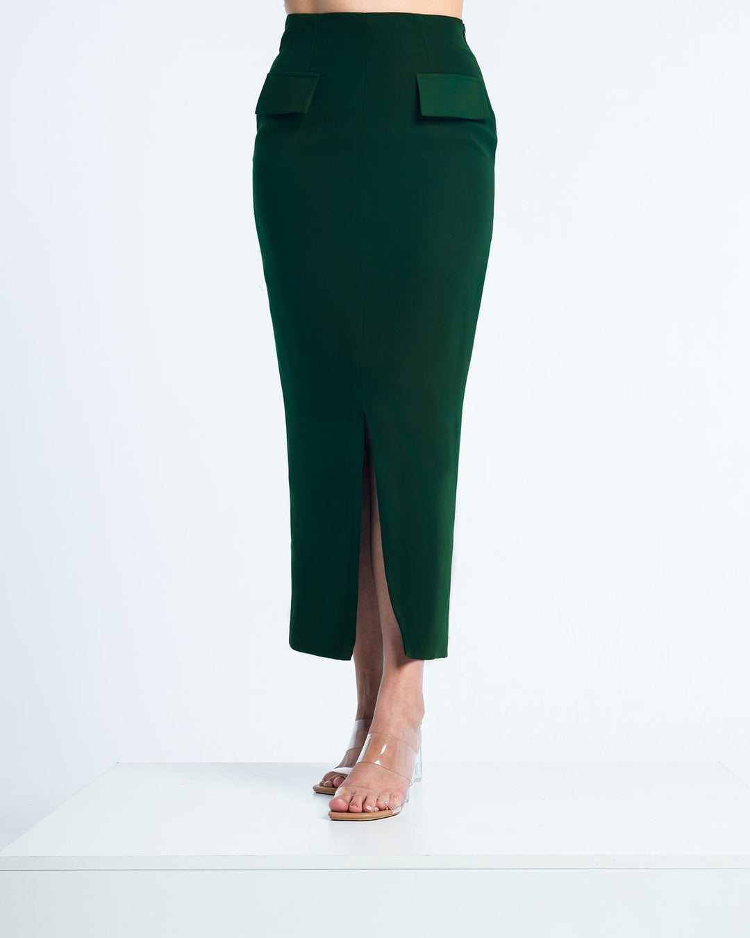 Woman wearing elegant dark green midi pencil skirt with front slit and pocket flaps