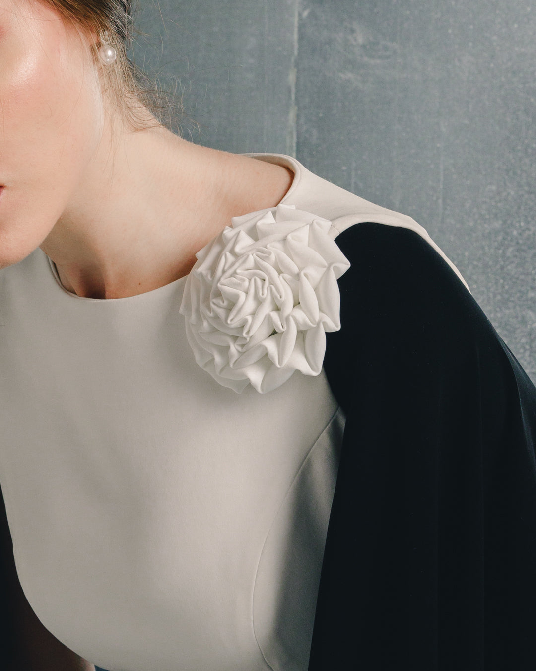 Elegant black and white dress with large fabric flower detail on shoulder