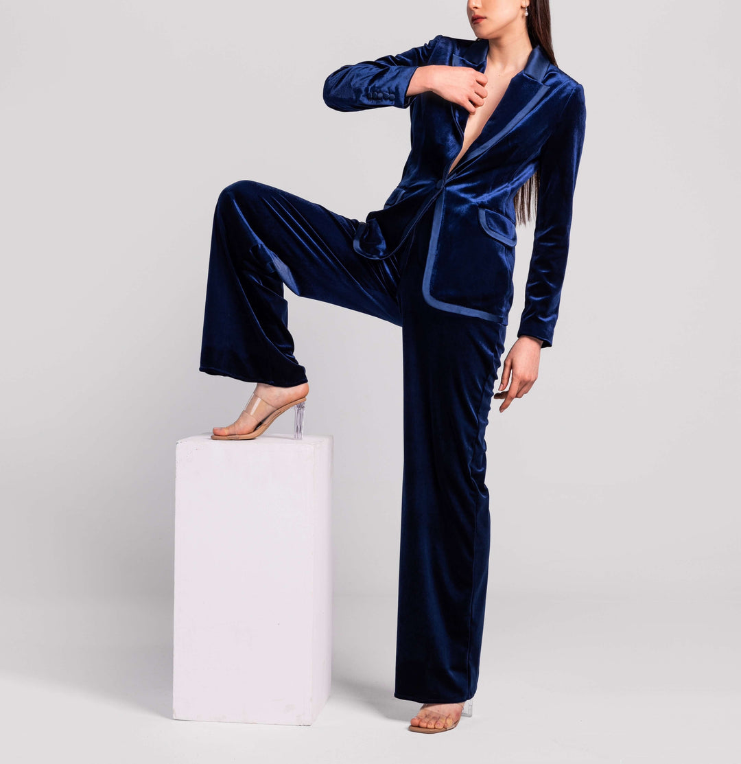Woman modeling a deep blue velvet suit with blazer and wide-leg pants, clear high heels
