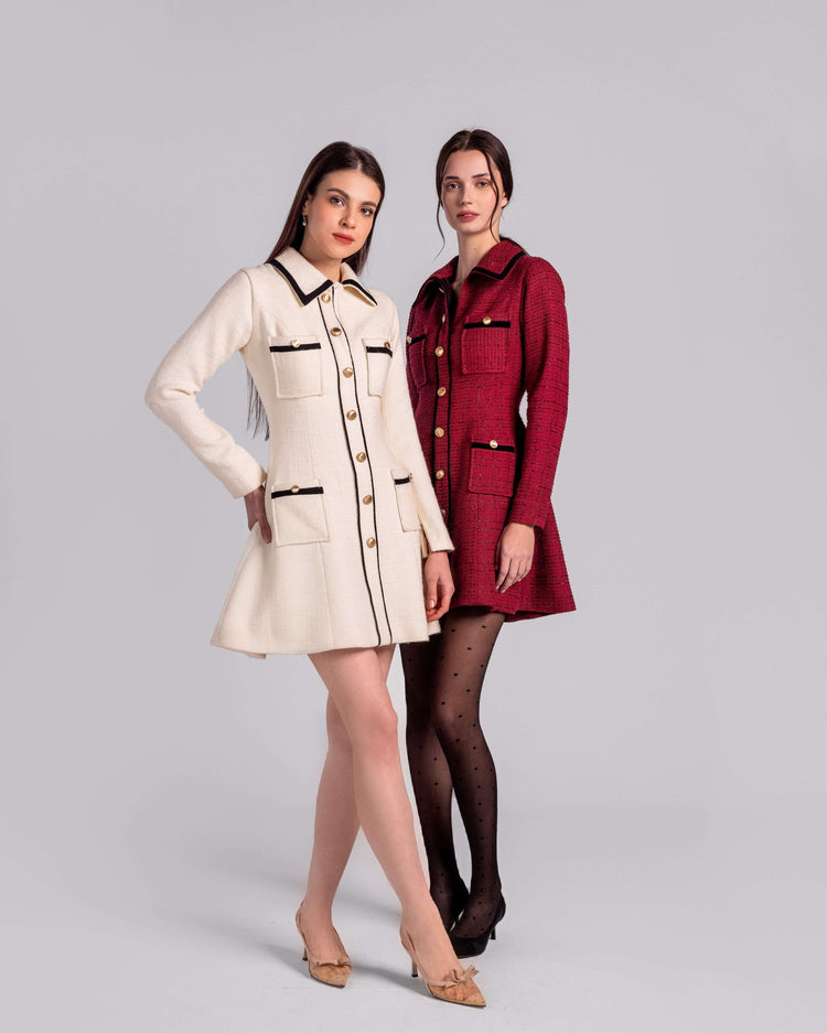 Two women modeling premium collared mini dresses, one cream and one red, with gold button details.