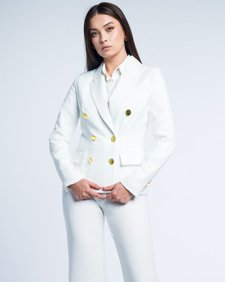 Woman models elegant white suit with gold buttons, tailored fit, fashion photography