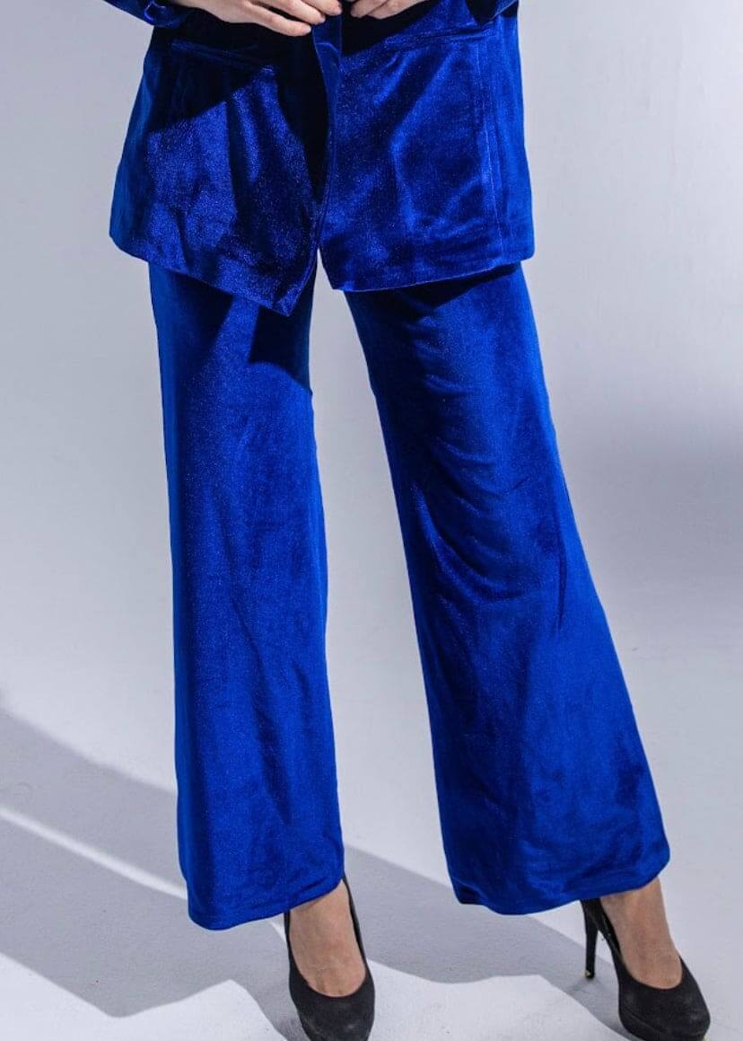 Woman wearing royal blue velvet suit with wide-leg pants and black heels